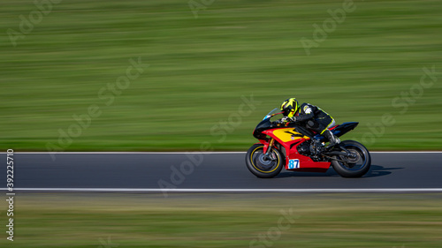 A panning shot of a racing bike cornering on a track.