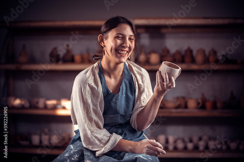 Ceramist master  demonstrates a finished clay bowl in a pottery workshop. Handwork. photo