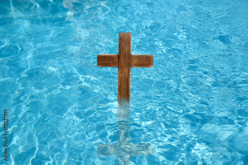 Foto Wooden cross in water for religious ritual known as baptism