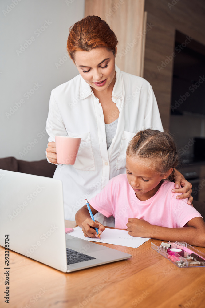 Mother helping with studying to her daughter Mother helping with studying to her daughter