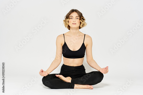Yoga asana woman crossed legs meditation light background room