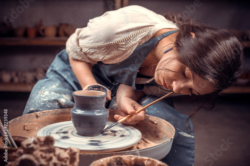 Charming craftsmen making ceramic pot on the pottery wheel . Making ceramic dishes.