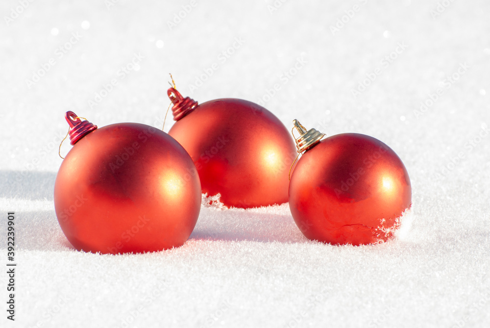 Three red christmas balls lie on the snow Three red christmas balls lie on the snow