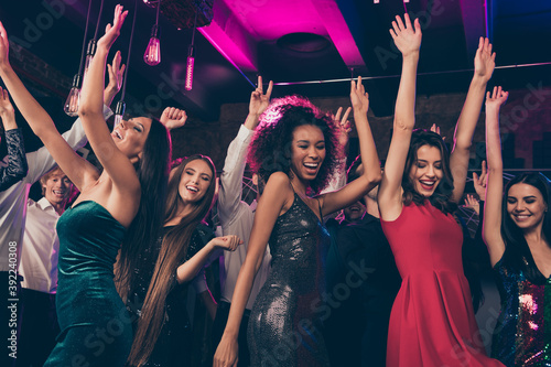 Photo portrait of wild crowd dancing together with hands in air at nightclub wearing beautiful formal dresses