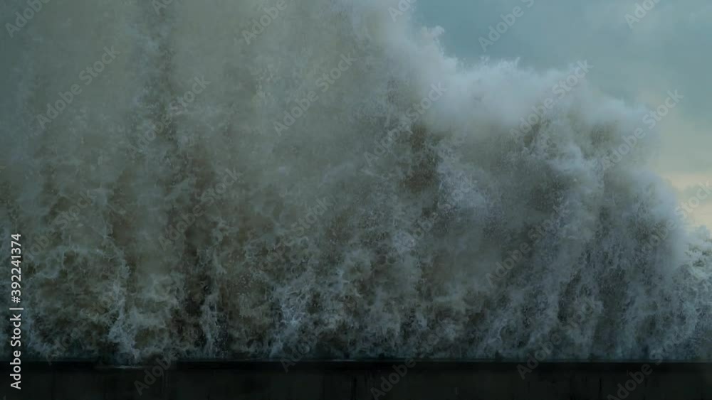 Powerful wave crashing into seawall with huge splashes