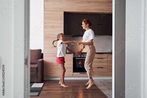 Mother and daughter jumping at the kitchen © Yakobchuk Olena