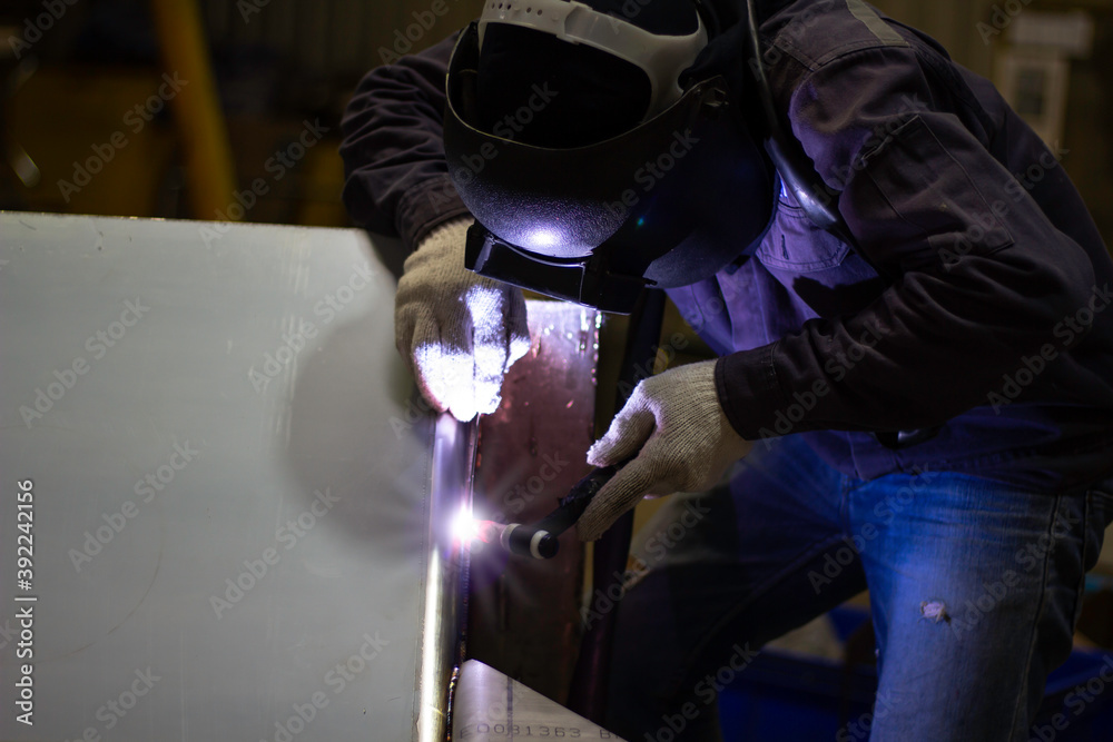 Metal workers use manual labor, Skilled welder, Factory workers making OT. Welder is welding the steel in the factory. Metal workers use manual labor, Skilled welder, Factory workers making OT. Welder is welding the steel in the factory.