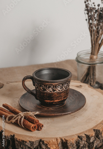 Handmade ceramic craft ware. Rustic napkin and kitchen tools with lavender and candle. Ceramic cup with cinnamon on a wooden stand. Handmade ceramic dishes