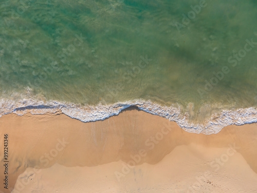 Aerial view of drone. Top view beach sea sand and surf. In summer day. Seawater on sandy beach. Nature background and travel concept.