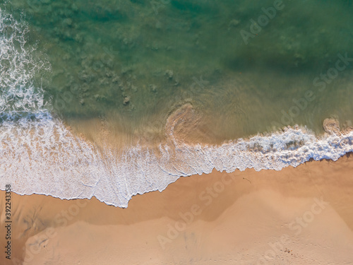 Aerial view of drone. Top view beach sea sand and surf. In summer day. Seawater on sandy beach. Nature background and travel concept.
