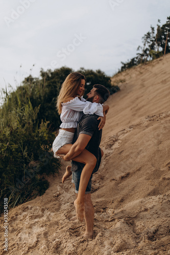 Romantic photo session of a young couple by the lake. Boy and girl summer walk.