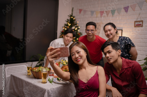 Asian group was taking a selfie while eating at a house party.