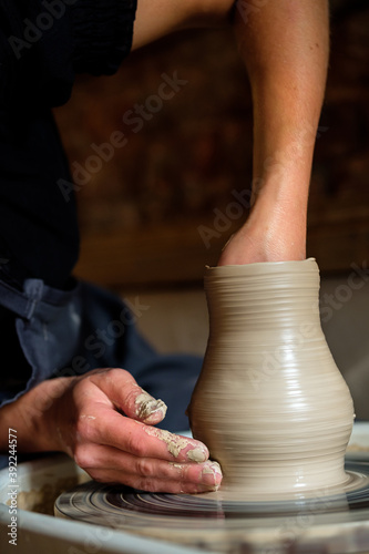 Female hands working with clay on a potter's wheel