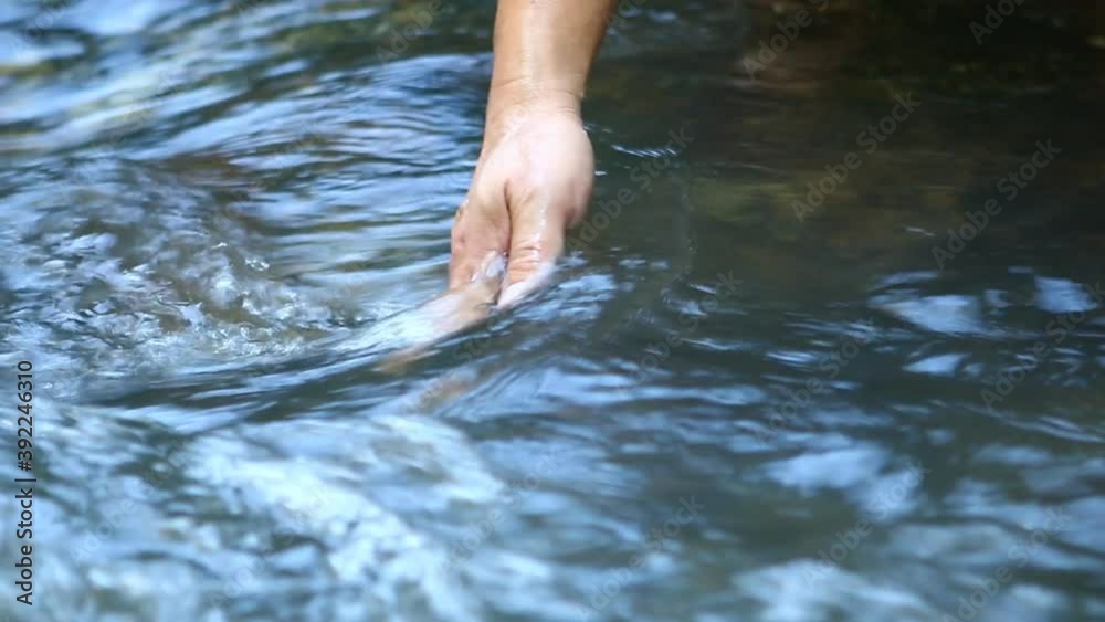 Man moving his hand in the river, Chiangmai Thailand Man moving his hand in the river, Chiangmai Thailand