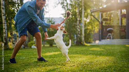 Canvas-taulu Man Plays with His Smooth Fox Terrier Dog Outdoors