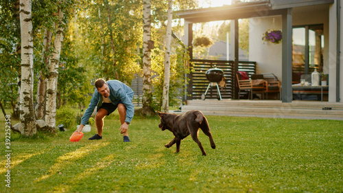 Photography Handsome Man Plays Catch with Happy Brown Labrador Retriever Dog on the Backyard Lawn