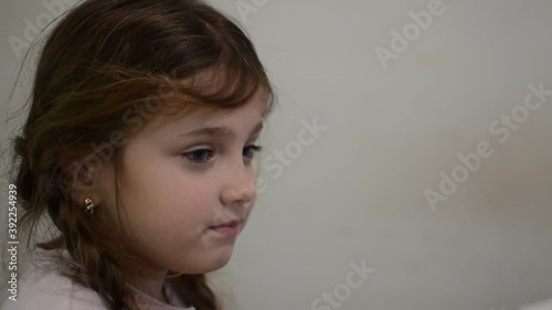 Little girl child blows snot out of nose into paper handkerchief during a cold photo