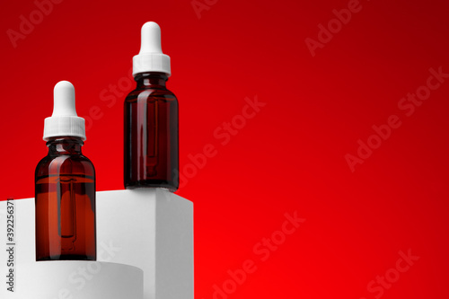 Beauty oil bottle with pipette against red background