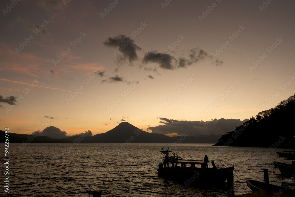 Guatemala, Central America: sunset with boats at lake Atitlán (Atitlan) with volcanos Atitlan, Toliman, San Pedro