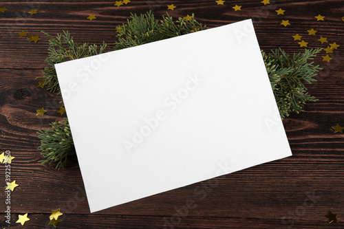 Christmas card mockup template with fir twigs and golden stars on a vintage wooden background. Design element for CHristmas and New Year congratulation, rsvp, thank you, greeting or invitation card