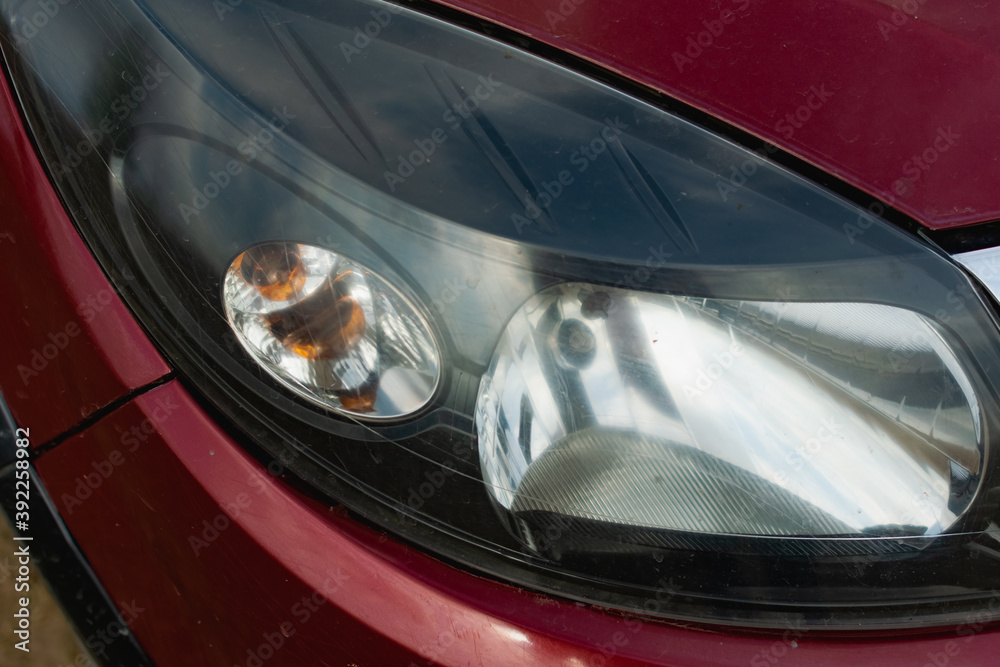 Large car headlights close-up, technical road lighting day and night. Front and rear colored lights and turn signals