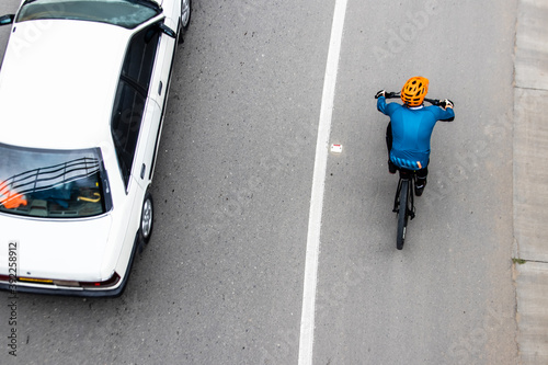 Fototapeta Naklejka Na Ścianę i Meble -  Overhead shot of  a cyclist being overtaken by a car on the road between Bogota and La Calera on the mountains in Colombia