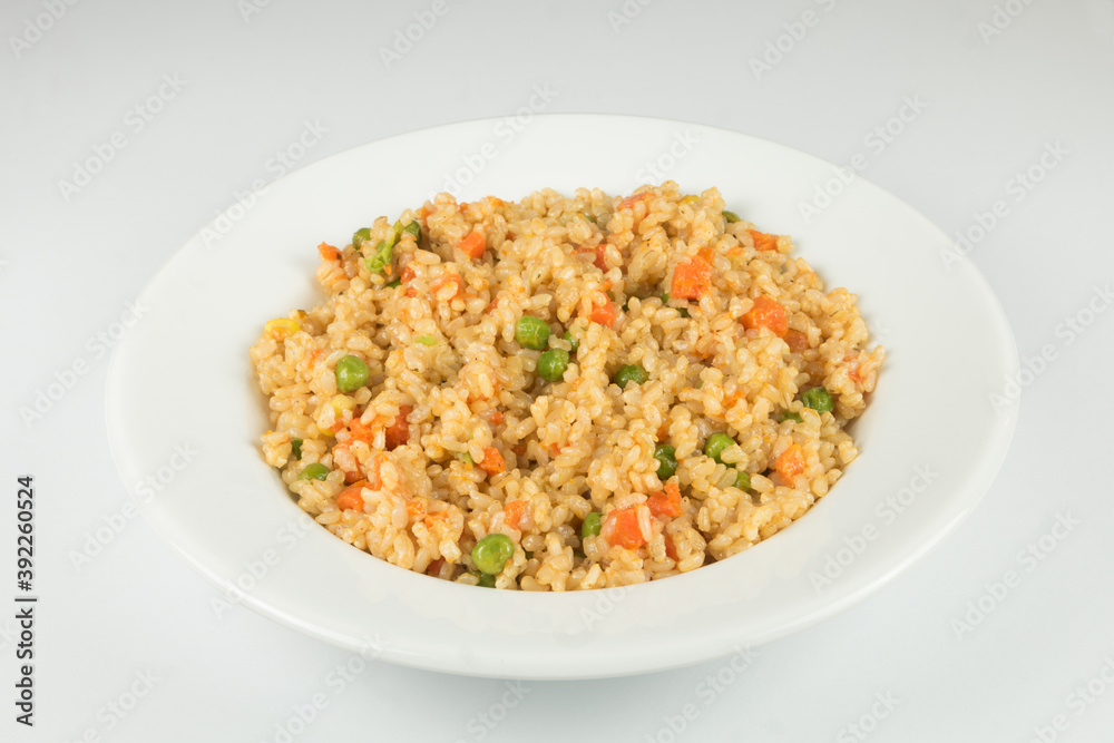 Natural rice with vegetables, risotto on the plate. White background.
Natural rice with vegetables, risotto on the plate. White background.