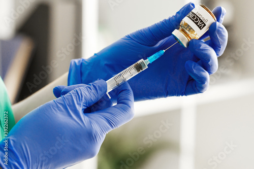 Doctor hands holding covid-19 vaccine preparing for vaccination of a patient