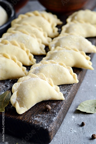 Dumplings with potatoes with herbs on a blue background. Varenyky, vareniki, pierogi, pyrohy - dumplings with filling. 