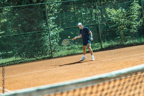 Active senior Caucasian man in sportswear playing tennis 