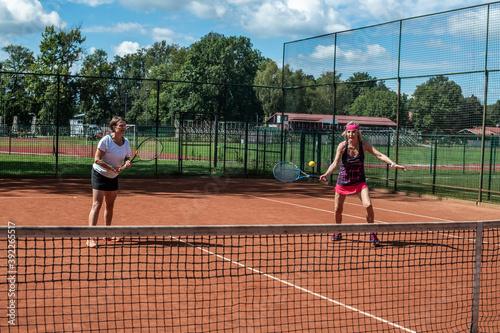 Two active senior Caucasian women in sportswear playing tennis © TheSupporter