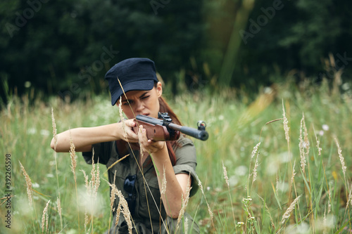 Woman on nature Weapon in hand hunting sight green leaves 