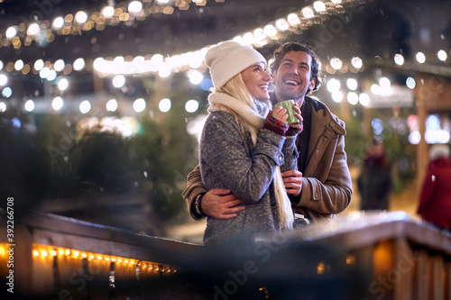 young couple in love enjoying the first snow, smiling. christmastime concept photo