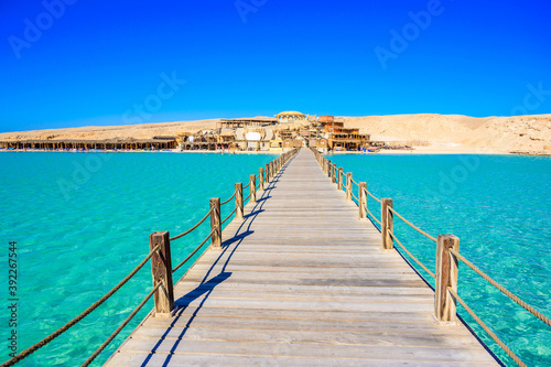 Wooden Pier at Orange Bay Beach with crystal clear azure water and white beach - paradise coastline of Giftun island, Mahmya, Hurghada, Red Sea, Egypt. photo