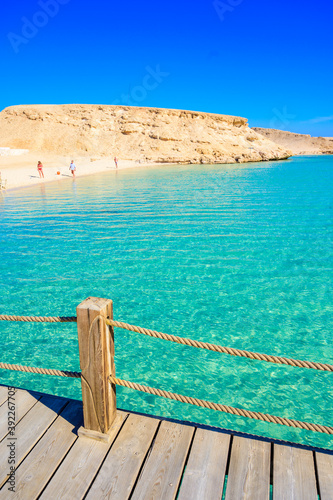 Wooden Pier at Orange Bay Beach with crystal clear azure water and white beach - paradise coastline of Giftun island, Mahmya, Hurghada, Red Sea, Egypt.