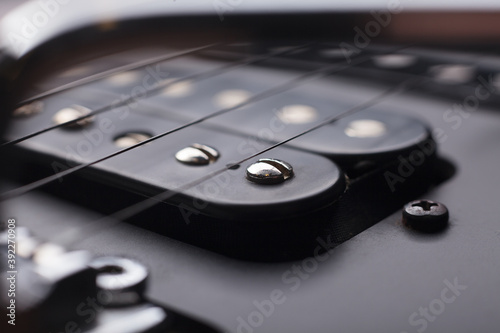 Elegant electric guitar black humbucker pickups detailed close up point of view showing poleplace screws under strings