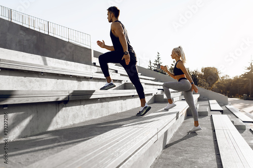 Sporty young couple, man and woman running together on the city stairs, sport, healthy lifestyle