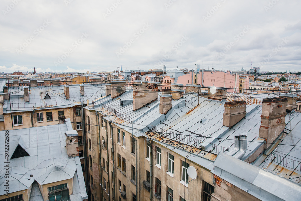 Fototapeta premium Iron roofs of houses in old city. Top view of winter St. Petersburg.
