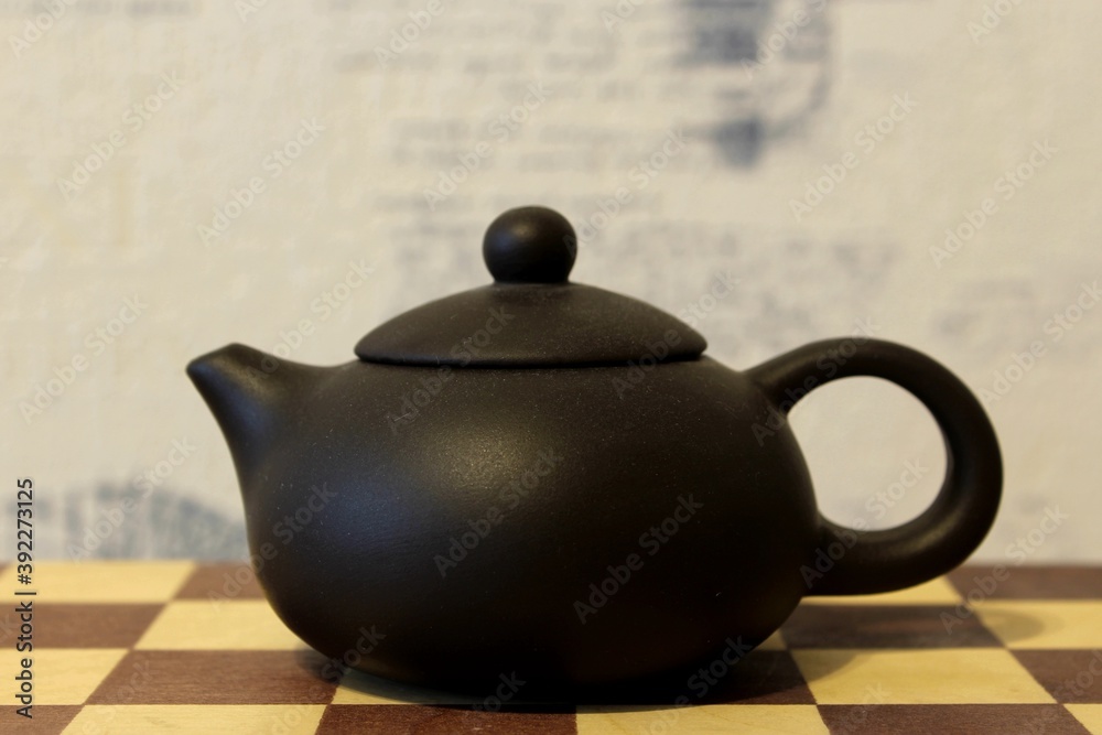 Small Issin teapot on a chessboard