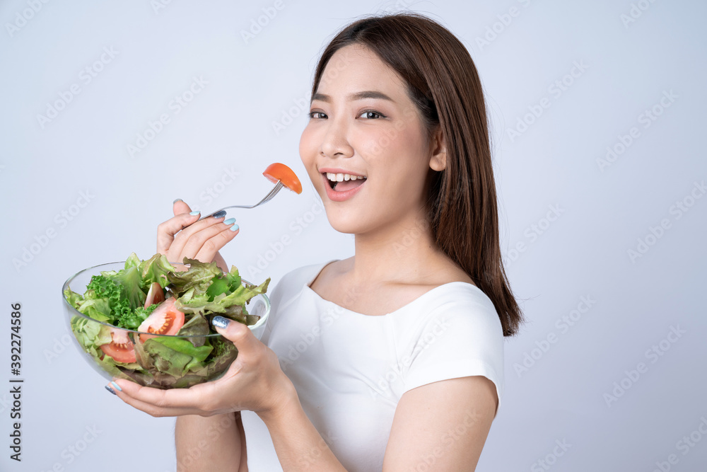 Healthy food, Asian girls hold Vegetable salad bowl and smile happily, Isolated on a white background. Healthy food, Asian girls hold Vegetable salad bowl and smile happily, Isolated on a white background.
