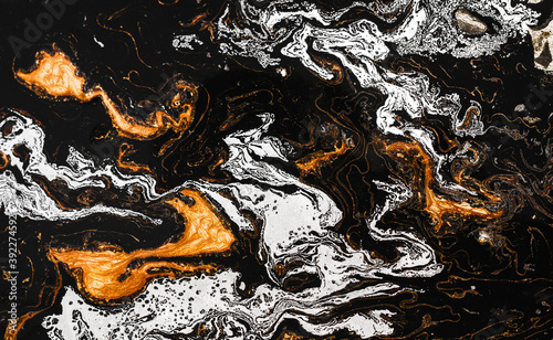 Luxury abstract fluid art painting in alcohol ink.  Imitation of marble stone, glowing golden veins on black blackground.