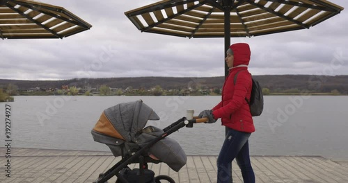Wallpaper Mural Young mother walking with baby carriage on the pier on the beach. Happy mother and baby walking in the Park on the outdoors at the sea, slow motion 60 fps. Relaxation. Torontodigital.ca