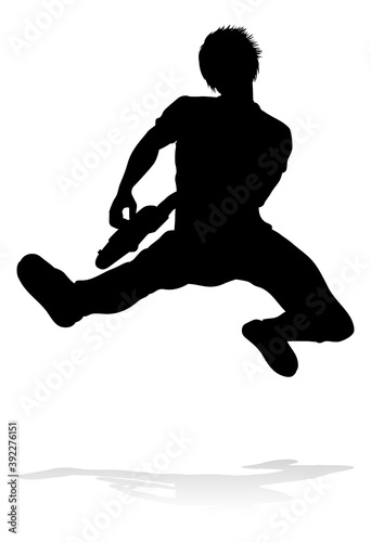 A guitarist musician in detailed silhouette playing his guitar musical instrument.