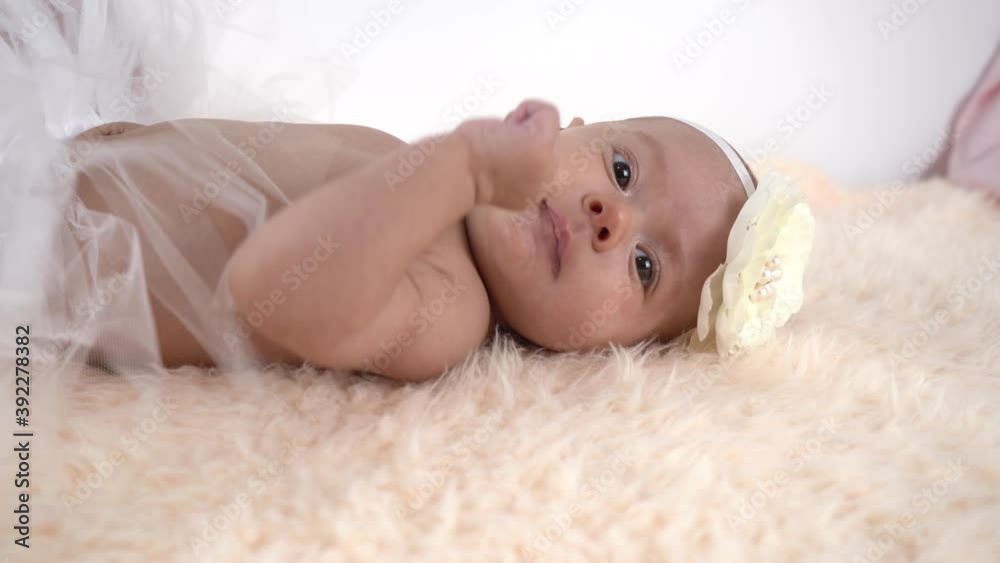 Beautiful newborn girl lying in a skirt and with a bow on her head Beautiful newborn girl lying in a skirt and with a bow on her head