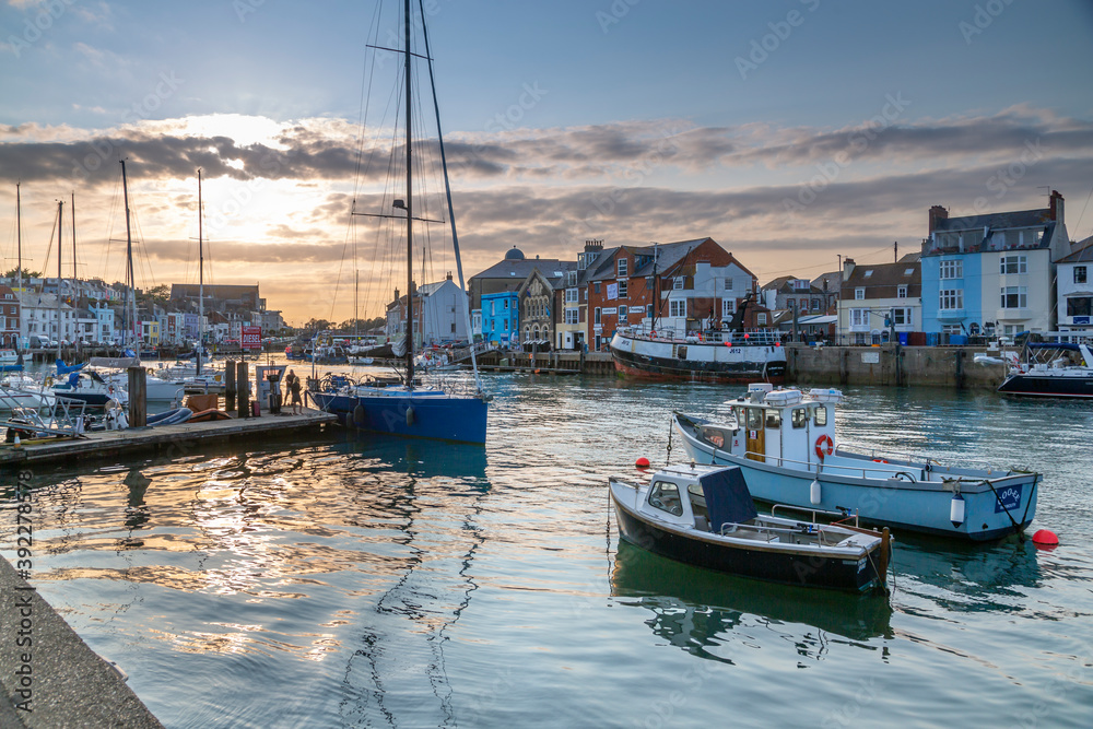 View of boats in the Old Harbour and quayside houses at sunset, Weymouth, Dorset View of boats in the Old Harbour and quayside houses at sunset, Weymouth, Dorset
