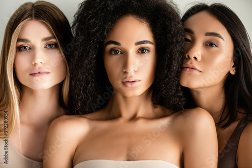 close up of young interracial models looking at camera isolated on white photo