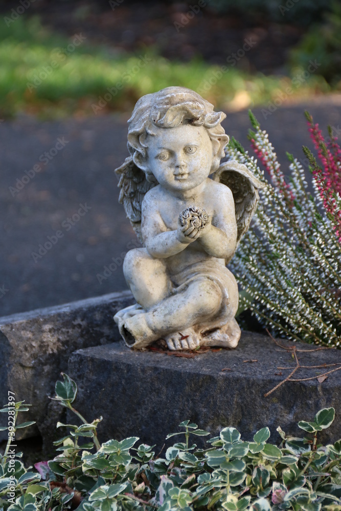 Kleiner Engel auf dem Friedhof im Herbst am Wegesrand