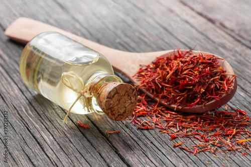 Canvas-taulu Glass bottle of saffron essential oil on wooden rustic background, spice or herb