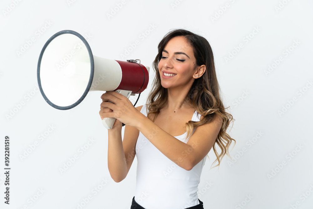 Young caucasian woman isolated on white background shouting through a megaphone to announce something Young caucasian woman isolated on white background shouting through a megaphone to announce something