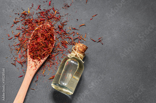 Canvas-taulu Glass bottle of saffron essential oil on rustic background, spice or herb oil co